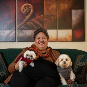 Roni Albert sitting on sofa with dogs.